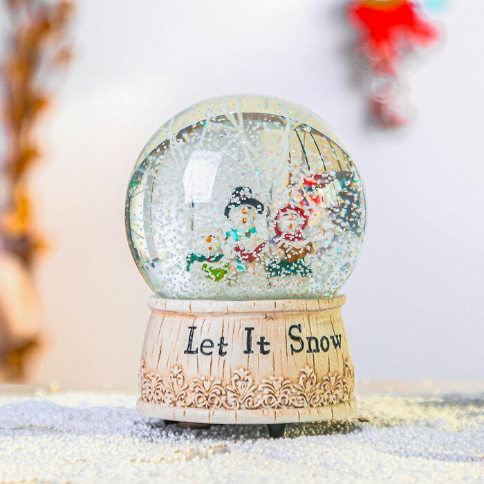 Christmas snow globe with festive figurines and snow, showcasing affordable Christmas decor ideas for 2024 celebrations.