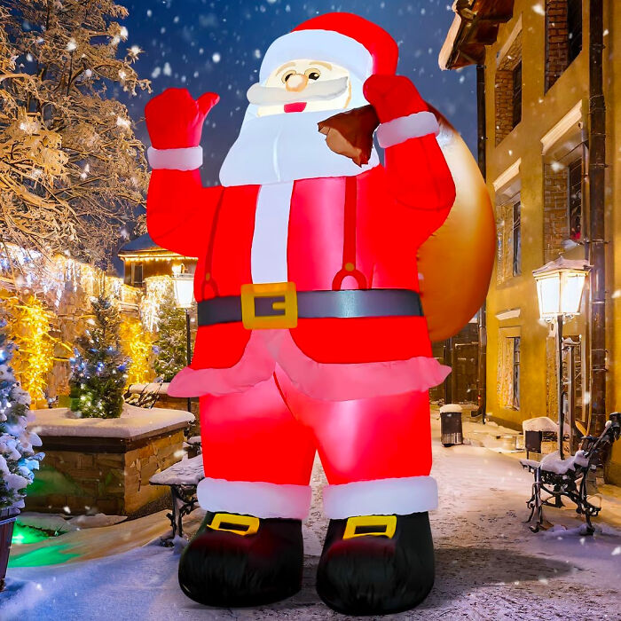Large inflatable Santa figurine on a snowy street decorated with affordable Christmas decor lights.