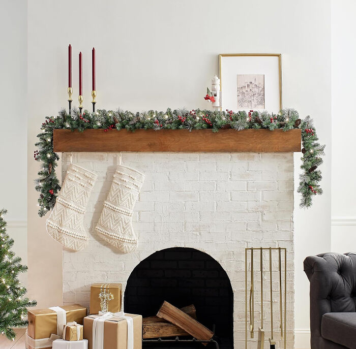 Leaves and pine cones arranged on a table next to golden tinsel, showcasing affordable Christmas decor ideas.