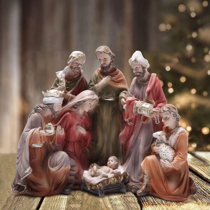 Nativity scene figurines surrounded by Christmas trees, showcasing affordable Christmas decor ideas for 2024.