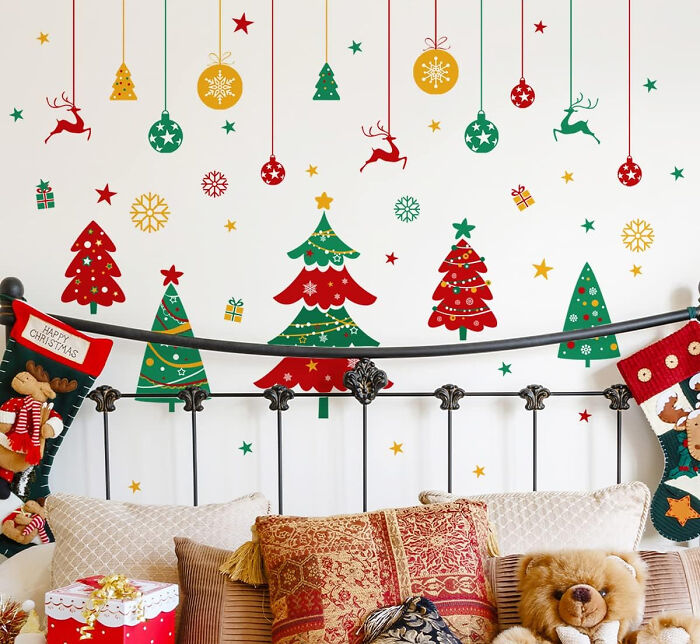 Cozy sofa with pillows and Christmas tree wall decals showcasing affordable Christmas decor ideas for 2024.