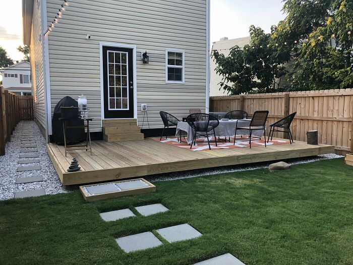 Small and simple floating deck in backyard, featuring patio furniture and cozy outdoor dining area for chic outdoors.