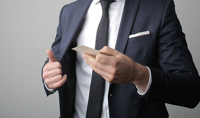 Man in Black Suit Holding a Calling Card