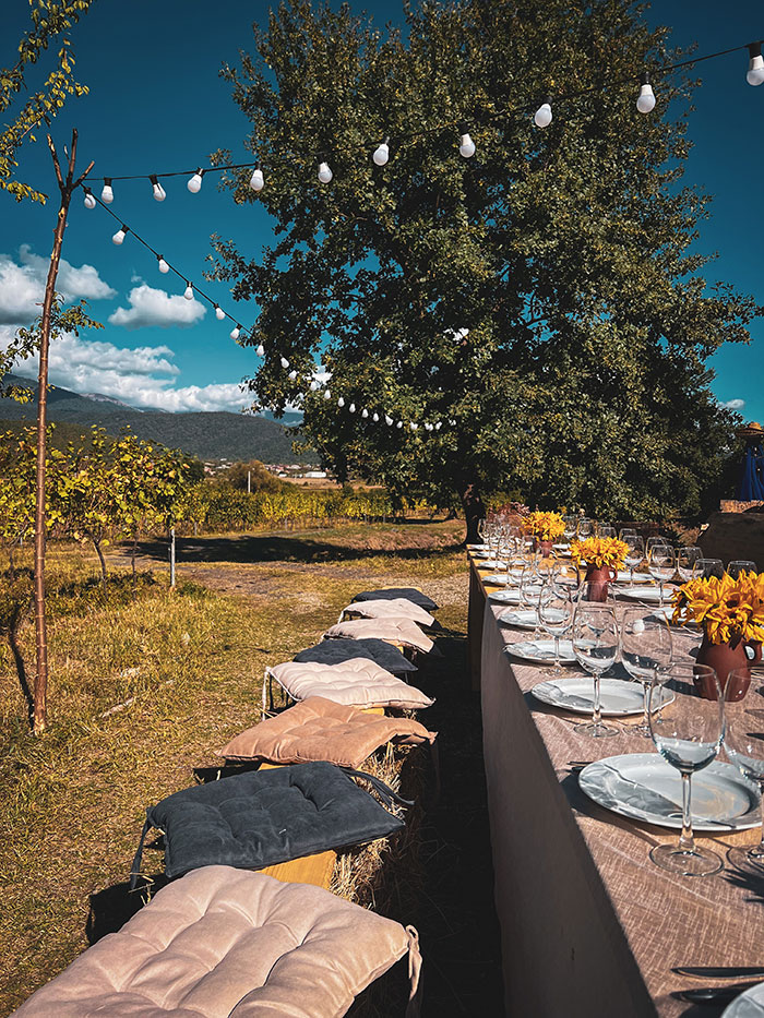 a long table with plates and glasses outside
