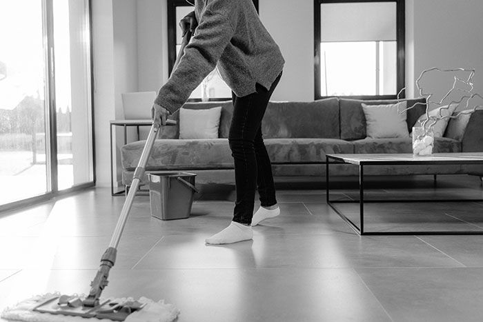 Person deep cleaning a floor with a mop Person deep cleaning a floor with a mop