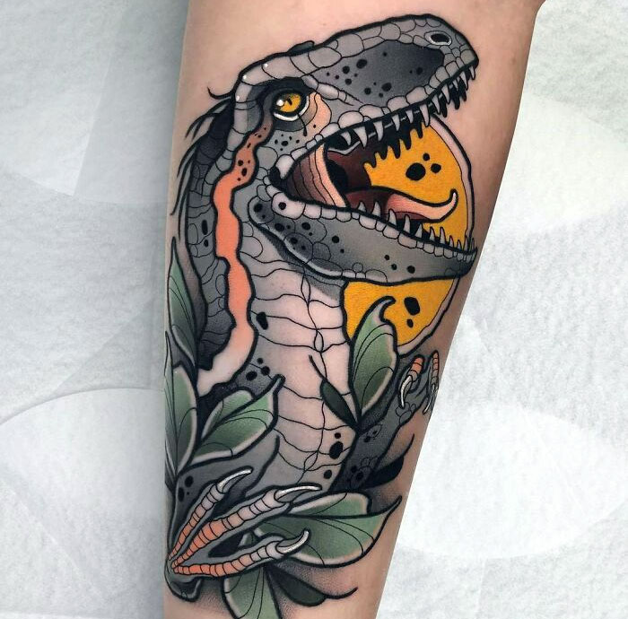 Stylized dinosaur tattoo on arm, featuring vibrant colors and intricate details.