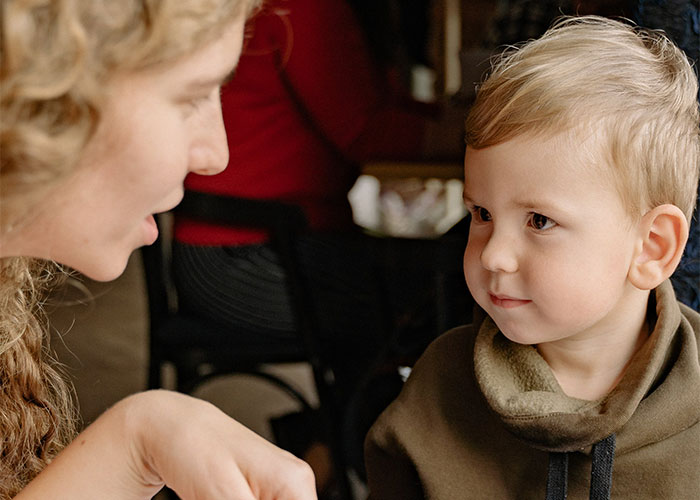 Mother talking to her young son indoors, illustrating outdated parenting myths about child behavior and communication.