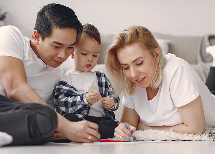Young parents and toddler engaged in creative play, illustrating common outdated parenting myths in modern family life.