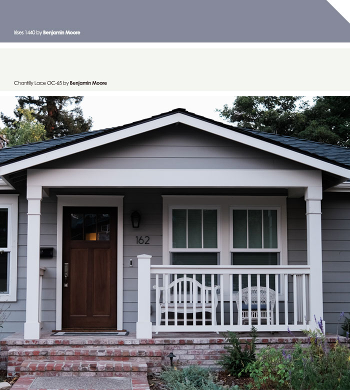Grey and white painted exterior house colors with a front porch and dark wooden door in a suburban neighborhood.
