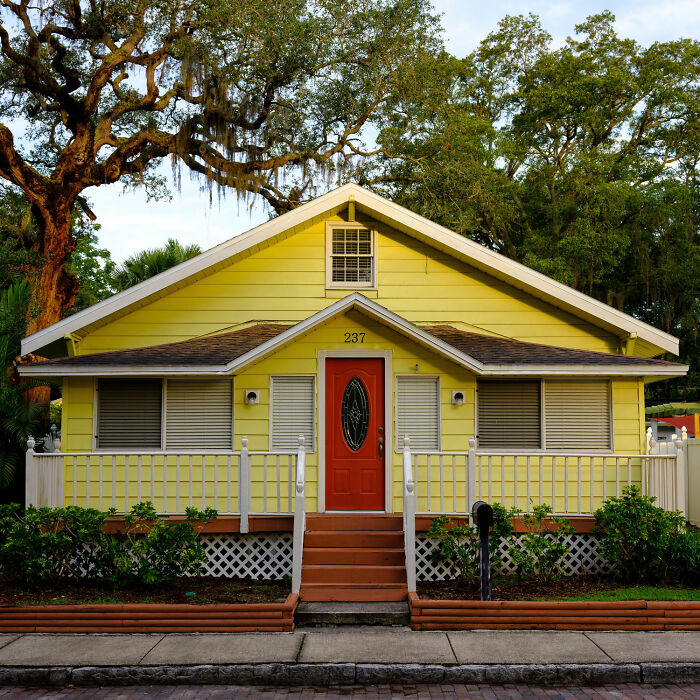 Yellow house with white fence