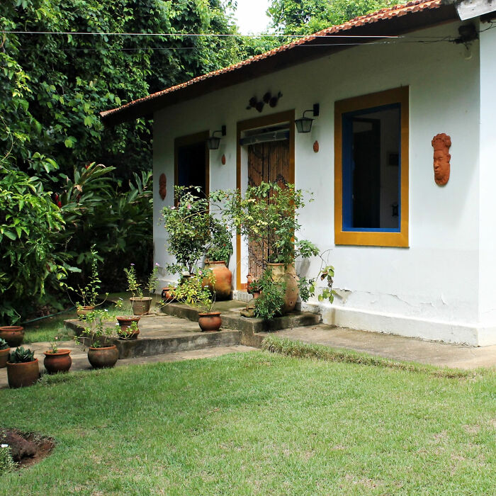 White house with pooted plants in yard