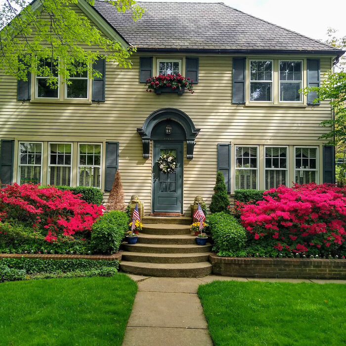 Gray concrete house with red flowers on the side