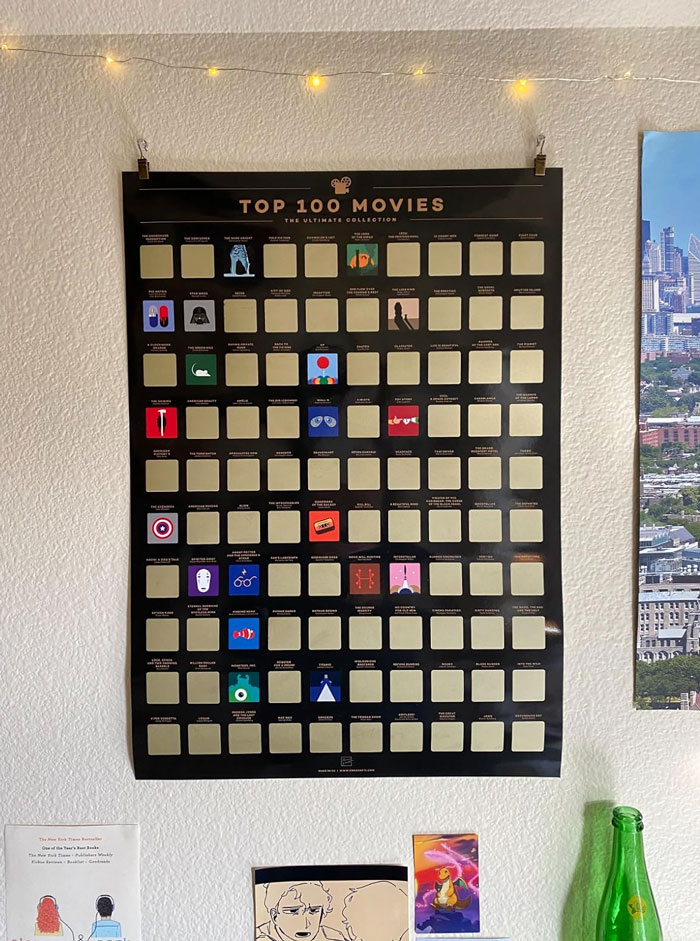 Scratch-off poster of top movies hung on wall, ideal for unique gifts for the partner who’s seen it all.