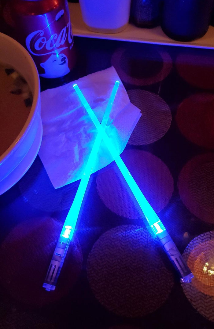 Blue glowing lightsabers crossed on a table, a creative gift idea for the partner who’s seen it all.