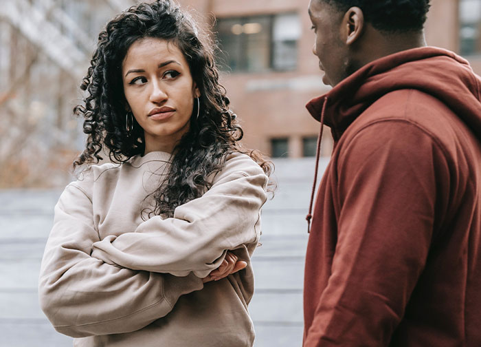 Man and woman in tense conversation about a new tattoo in urban setting. Man and woman in tense conversation about a new tattoo in urban setting.