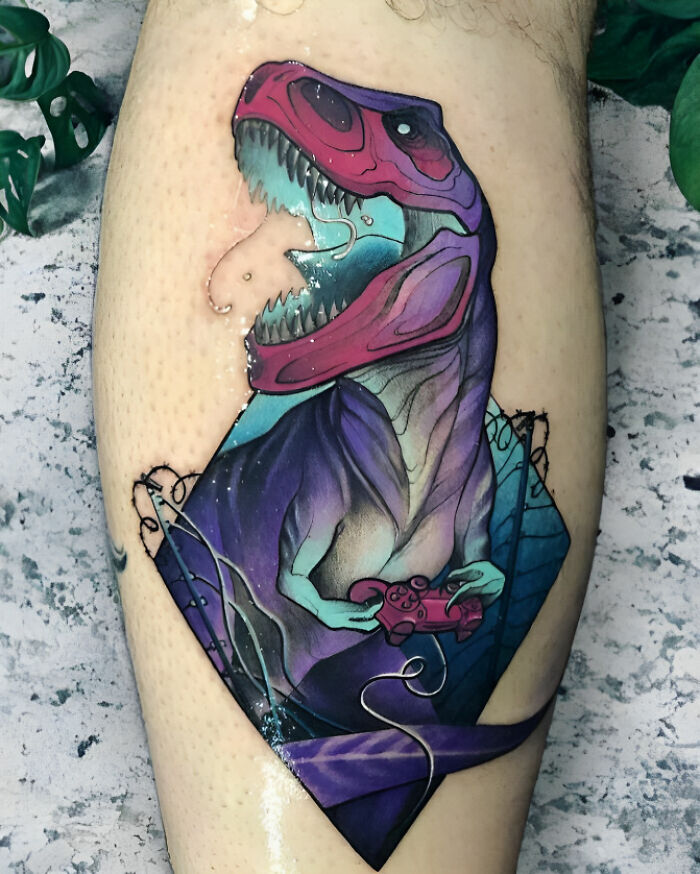 Colorful dinosaur tattoo featuring a T-rex playing video games, showcasing a creative tattoo idea.
