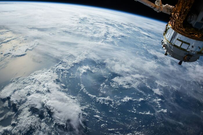 View of Earth from space with clouds and part of a spacecraft, showcasing our world beyond the nightmare narrative.