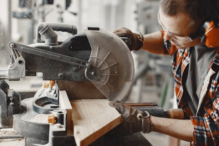 A craftsman using a sanding saw, wearing a protective sanding mask