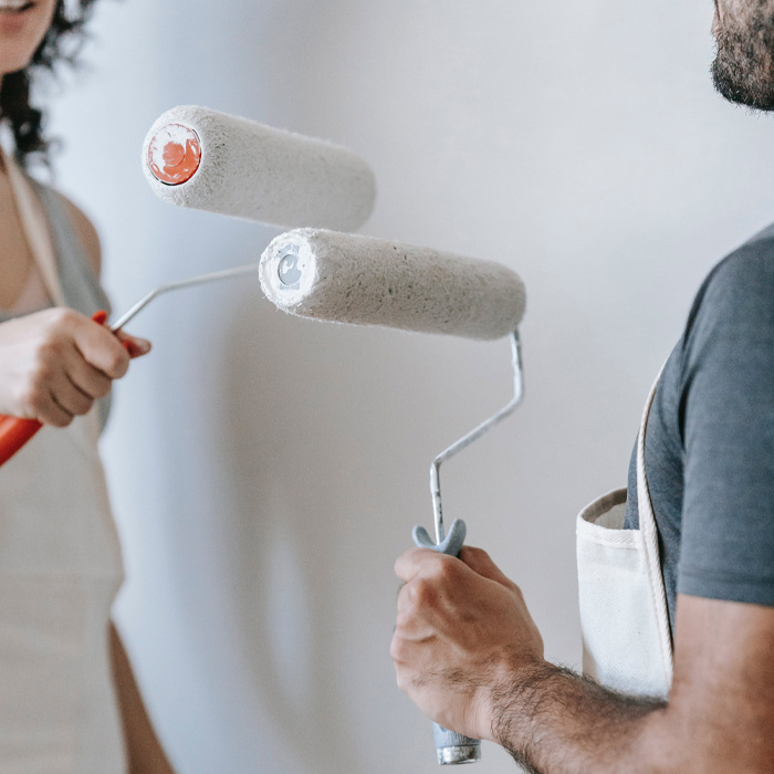 Man and woman holding rollers