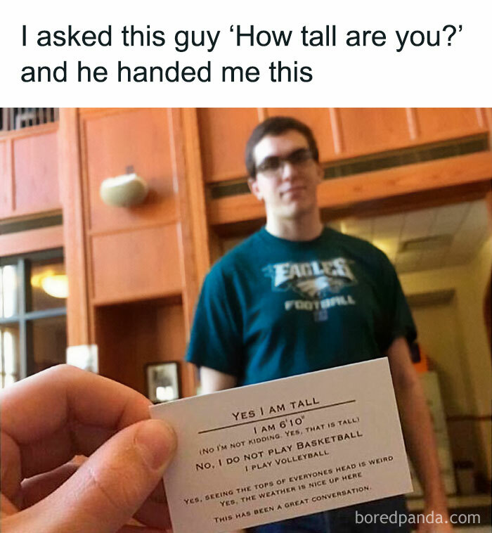 Man holding a card humorously explaining his height; funny memes.