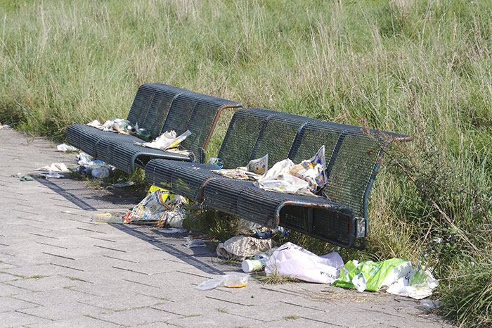 Benches beside a grassy area, covered in litter, illustrating an intriguing fact you probably didn’t learn in school.