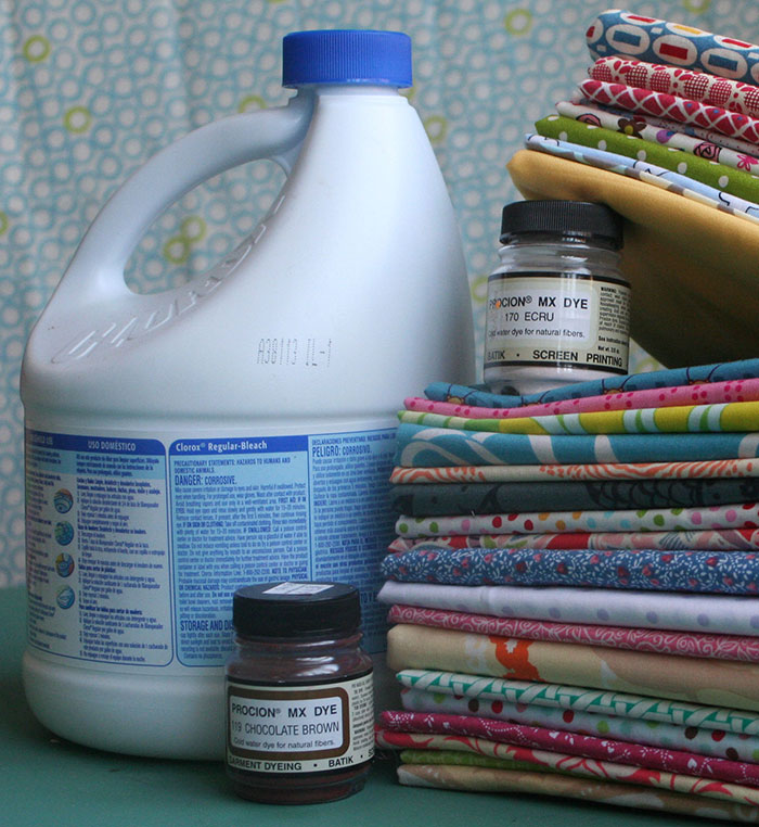 Procion dyes and bleach with colorful fabric stacks for school projects.