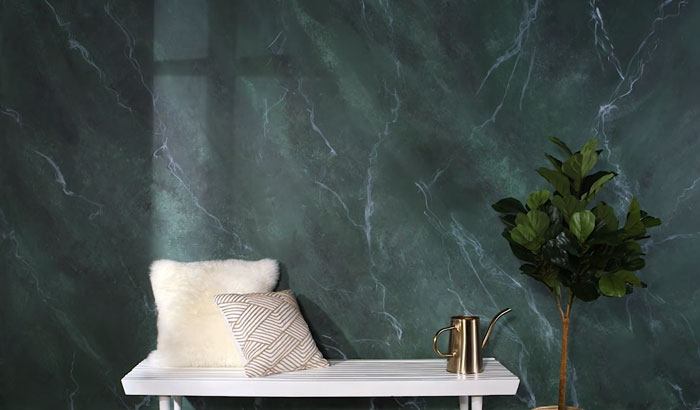 Marble wall painting design with white bench, patterned pillows, gold watering can, and green indoor plant in minimalist setting