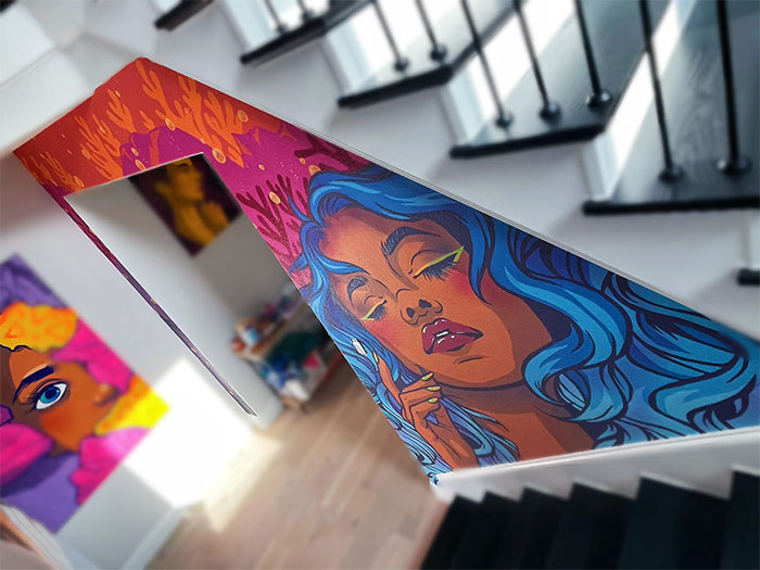 Colorful mural wall painting design featuring a vibrant portrait with blue hair on an indoor stair railing.