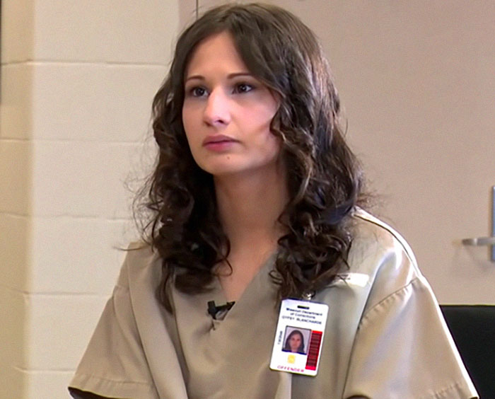 Person in a prison uniform with an ID badge, discussing the Menendez Brothers' freedom.