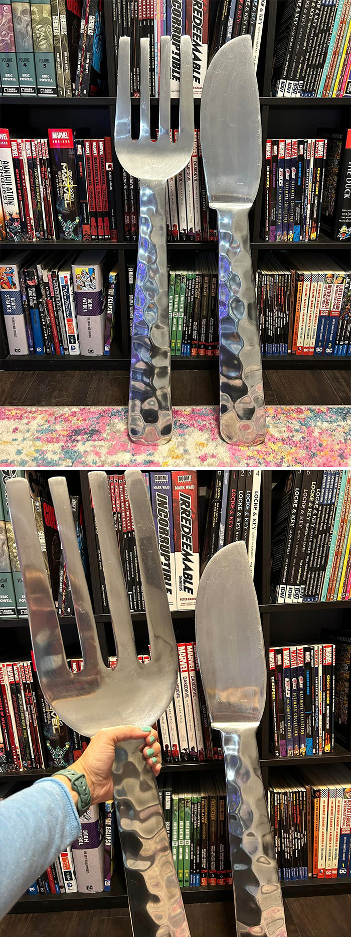 Oversized fork and knife decor found at thrift store displayed in front of comic book shelves and colorful rug.