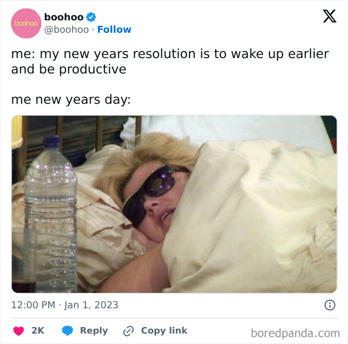 Person wearing sunglasses lying in bed wrapped in blankets, humorously illustrating new year's resolutions on New Year's Day.