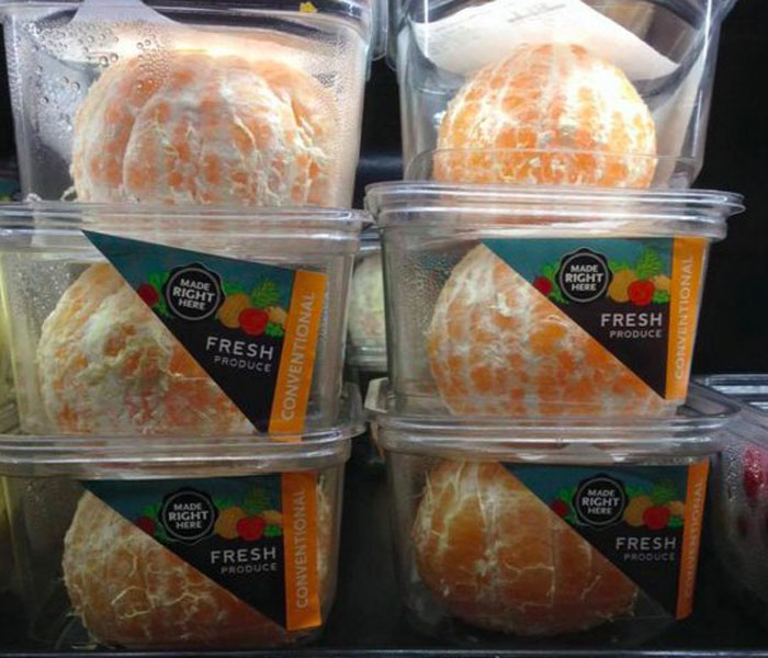 Packaged fresh produce in plastic containers on a store shelf.