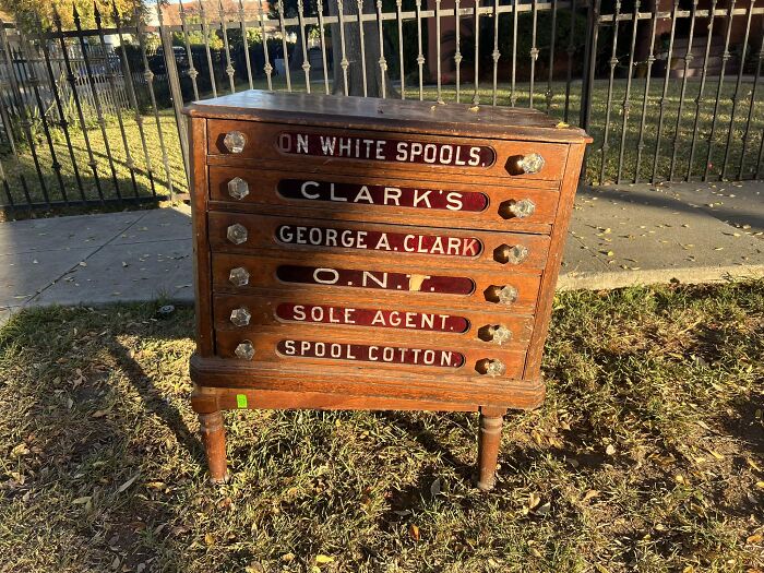Vintage wooden cabinet with labeled drawers found at a thrift store, showcasing unique collectible furniture luck.