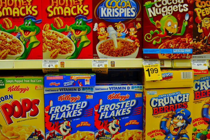 Various colorful cereal boxes displayed on a grocery store shelf.