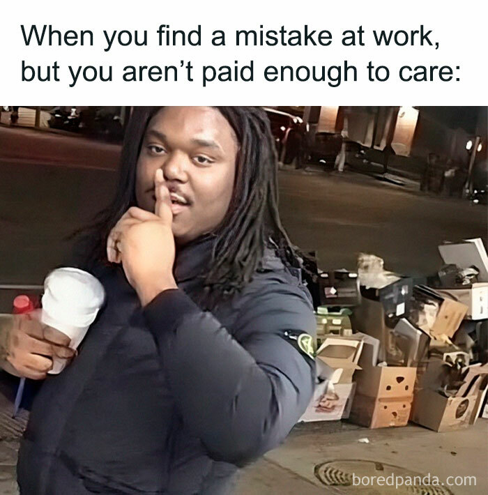 Man holding coffee with a finger on his lips, standing beside boxes at night, captioned for a funny work meme about mistakes.