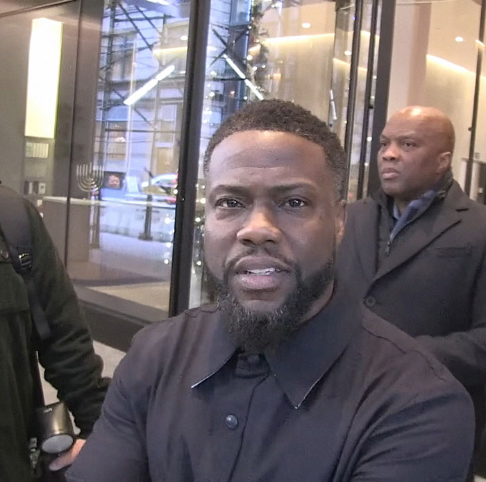 A person outside a building entrance, wearing a dark coat, discussing Greta Gerwig's response to Jo Koy's Barbie joke.