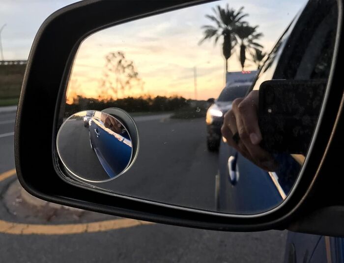 Car side mirror reflecting a sunset road scene with palm trees, illustrating practical life hacks for everyday situations.