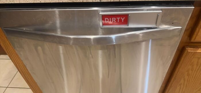 Stainless steel dishwasher with a red dirty indicator showing, highlighting practical life hacks for everyday household tasks.