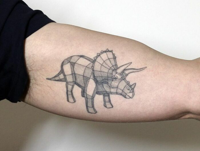 Geometric triceratops tattoo on forearm, showcasing a cool dinosaur design executed perfectly.