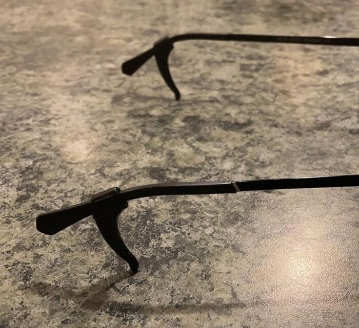 Broken eyeglass frame lying on a textured surface, illustrating a common life hack for quick repairs.