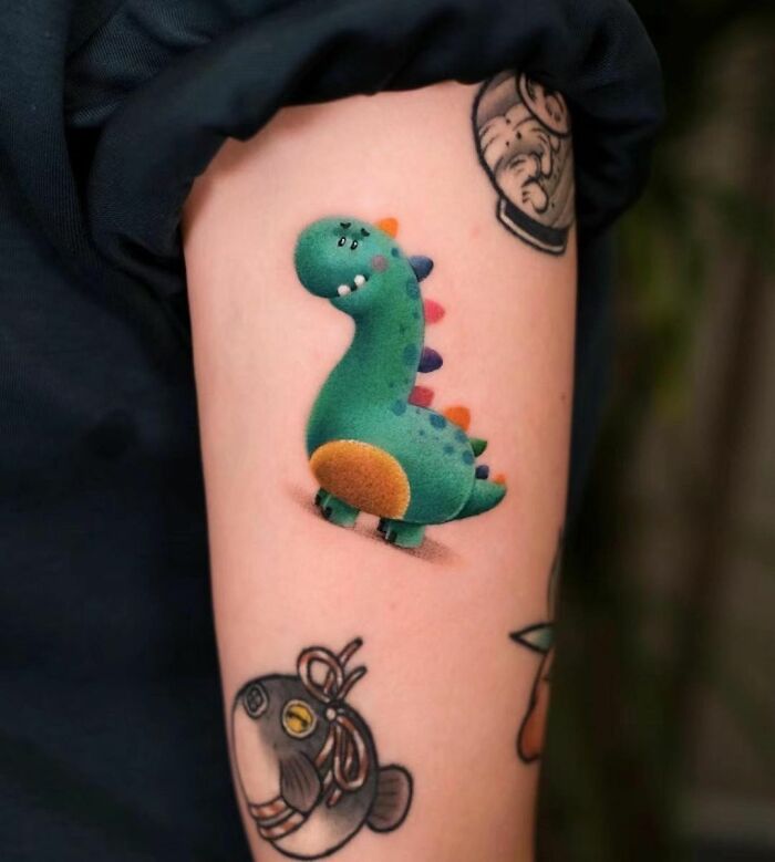 Colorful dinosaur tattoo on forearm, showcasing a cool and creative design.