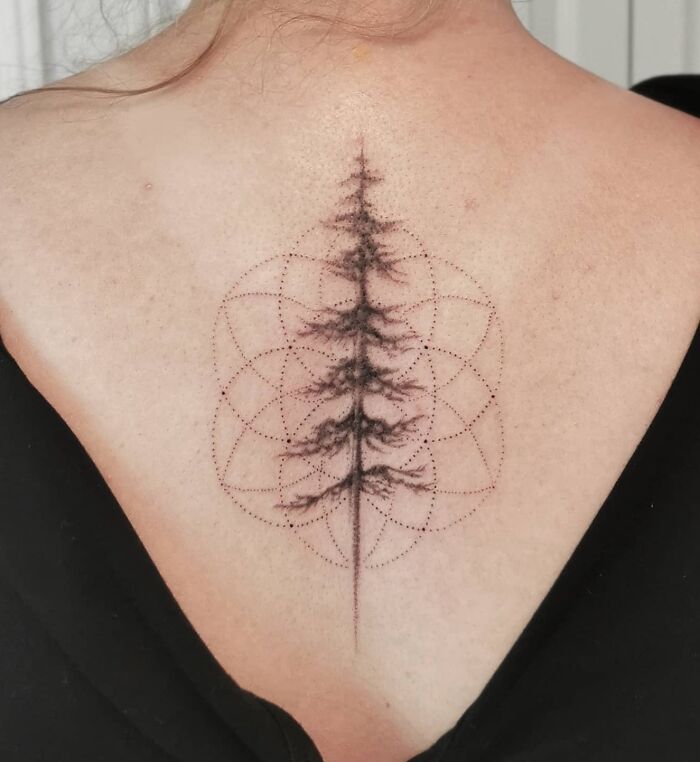 Beautiful spine tattoo of a tree with geometric pattern, showcasing intricate design on bare back.