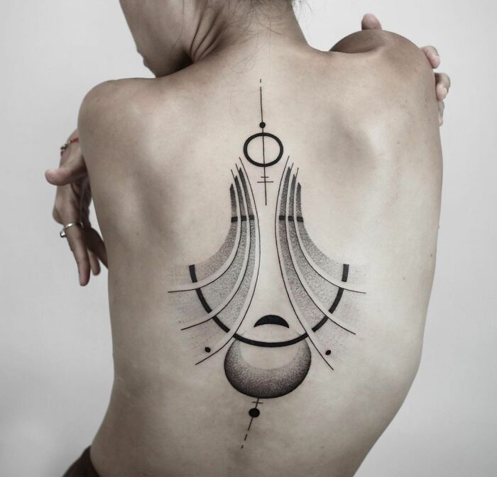 Geometric spine tattoo design on a person's back.