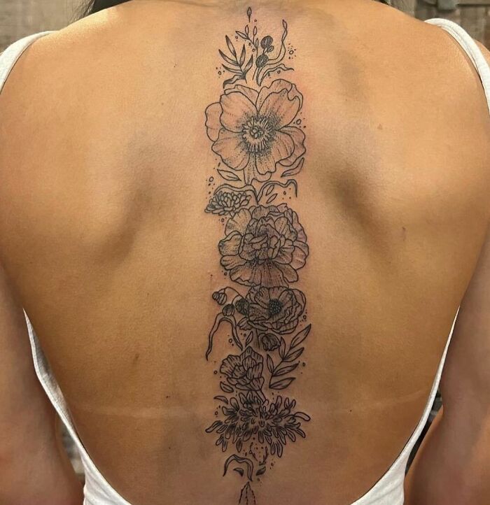 Floral spine tattoo showcases intricate design and detail.