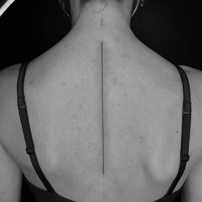 Minimalist spine tattoo design on a woman's back.