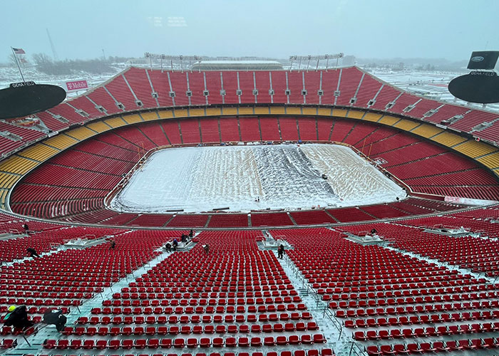 Snow-covered Chiefs-Dolphins stadium, red seats empty, capturing record-cold game atmosphere. Snow-covered Chiefs-Dolphins stadium, red seats empty, capturing record-cold game atmosphere.