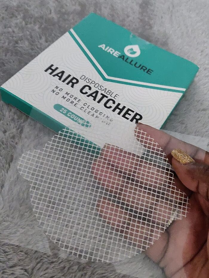 Disposable hair catcher held by hand with gold nail polish, packaging in background showing product use life hacks concept.