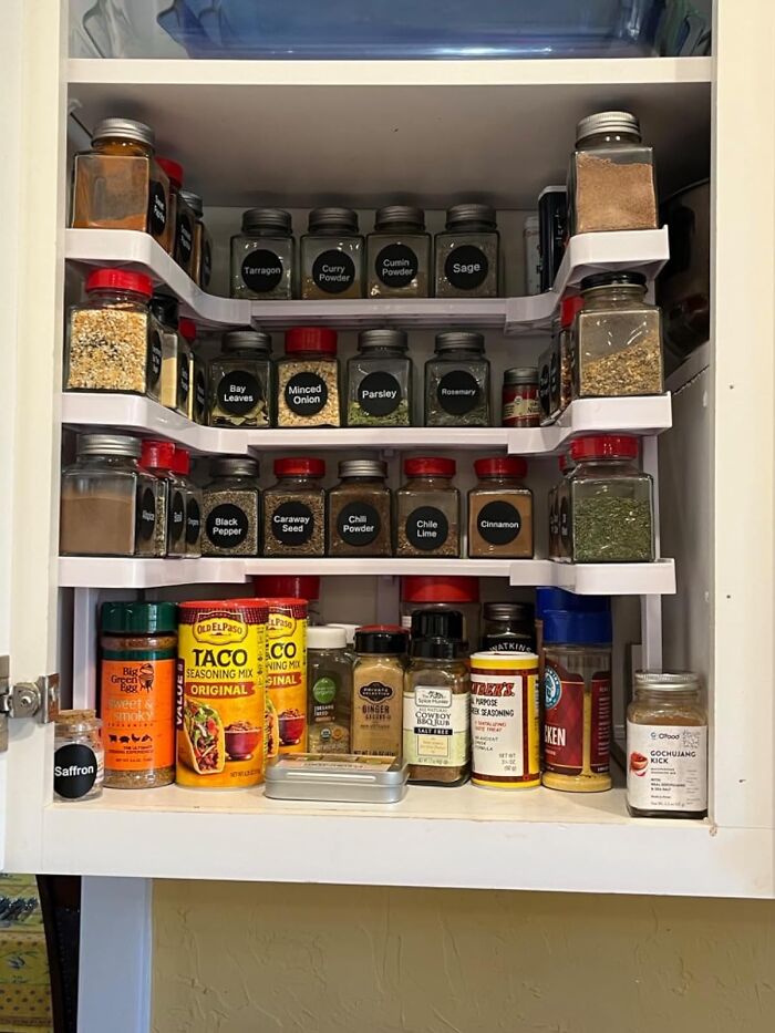 Organized spice cabinet with labeled jars and seasoning mixes showcasing practical life hacks for efficient kitchen storage.