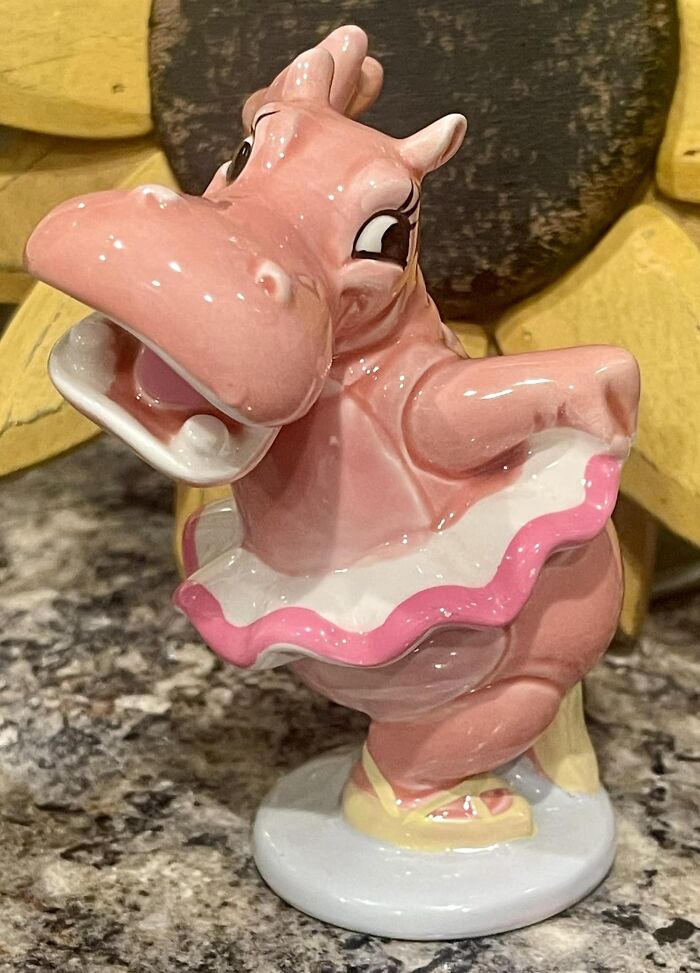 Pink ceramic hippo figurine in a ballet outfit found at thrift stores and flea markets on a granite surface.