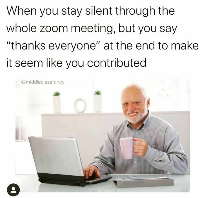 Smiling person holding a mug during a virtual work-from-home meeting with a laptop, looking amused.